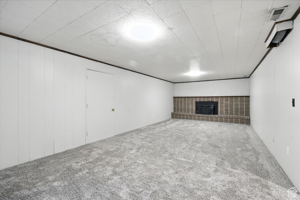 Finished basement with carpet flooring and a fireplace