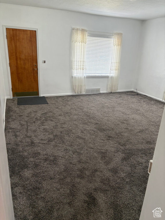 Carpeted spare room with baseboards