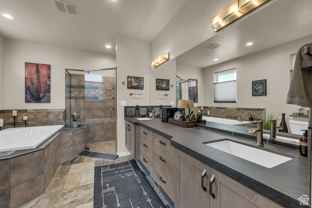 Bathroom featuring double vanity, a stall shower, a garden tub, and recessed lighting