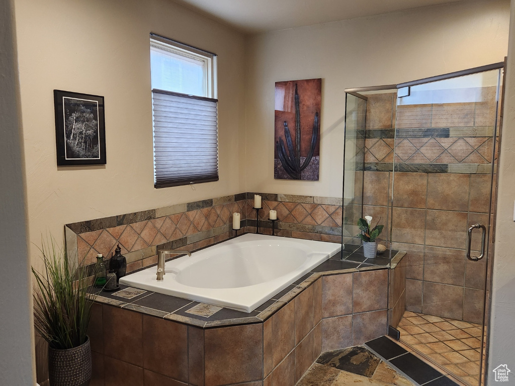 Bathroom featuring a bath and a shower stall