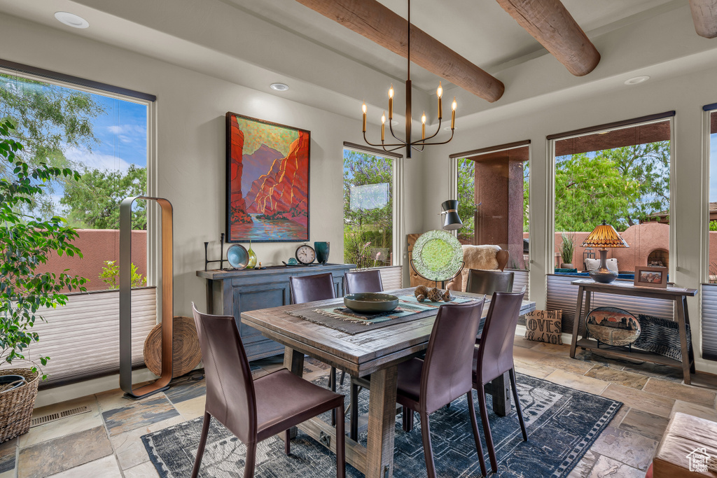 Dining space with stone tile flooring, beamed ceiling, a chandelier, and recessed lighting