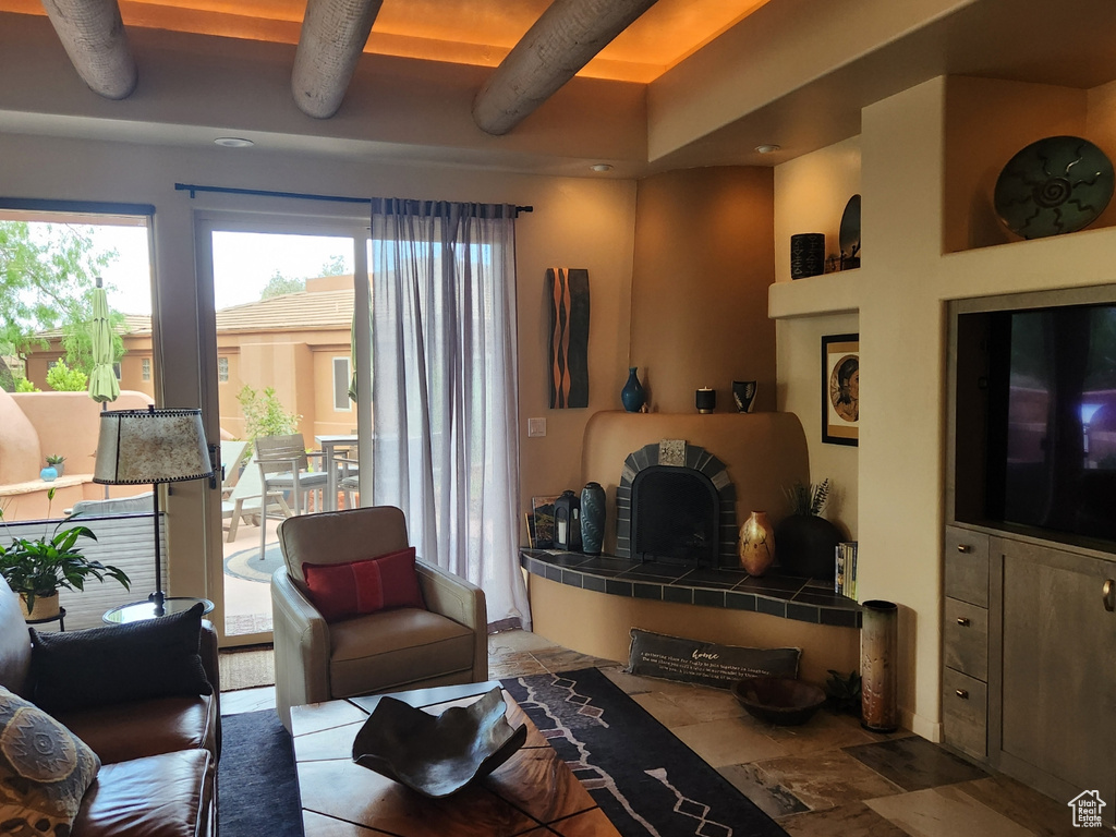 Living room featuring beam ceiling and stone finish floors