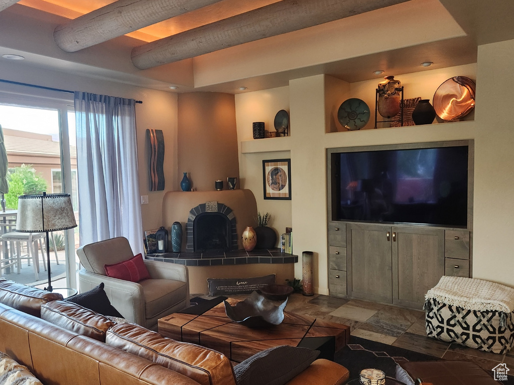 Living room featuring beam ceiling and stone finish floors