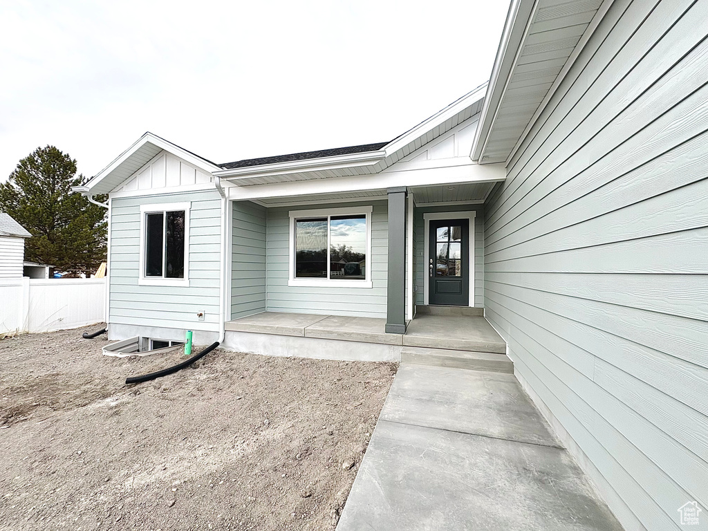 Property entrance with board and batten siding and covered porch