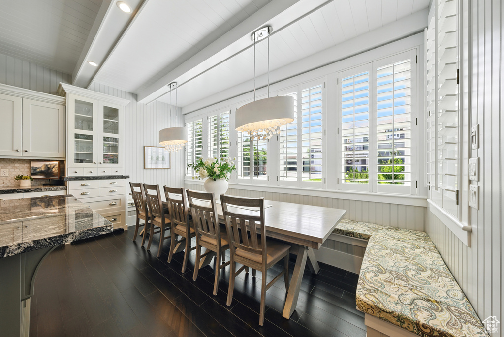 Dining room with dark wood-type flooring and beamed ceiling