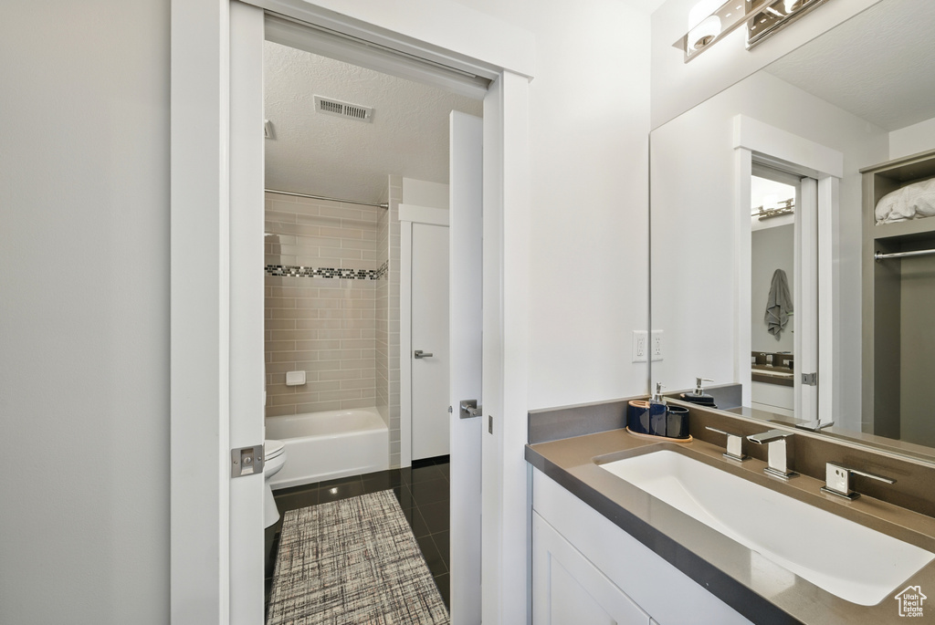 Full bath with vanity, tile patterned flooring, and washtub / shower combination