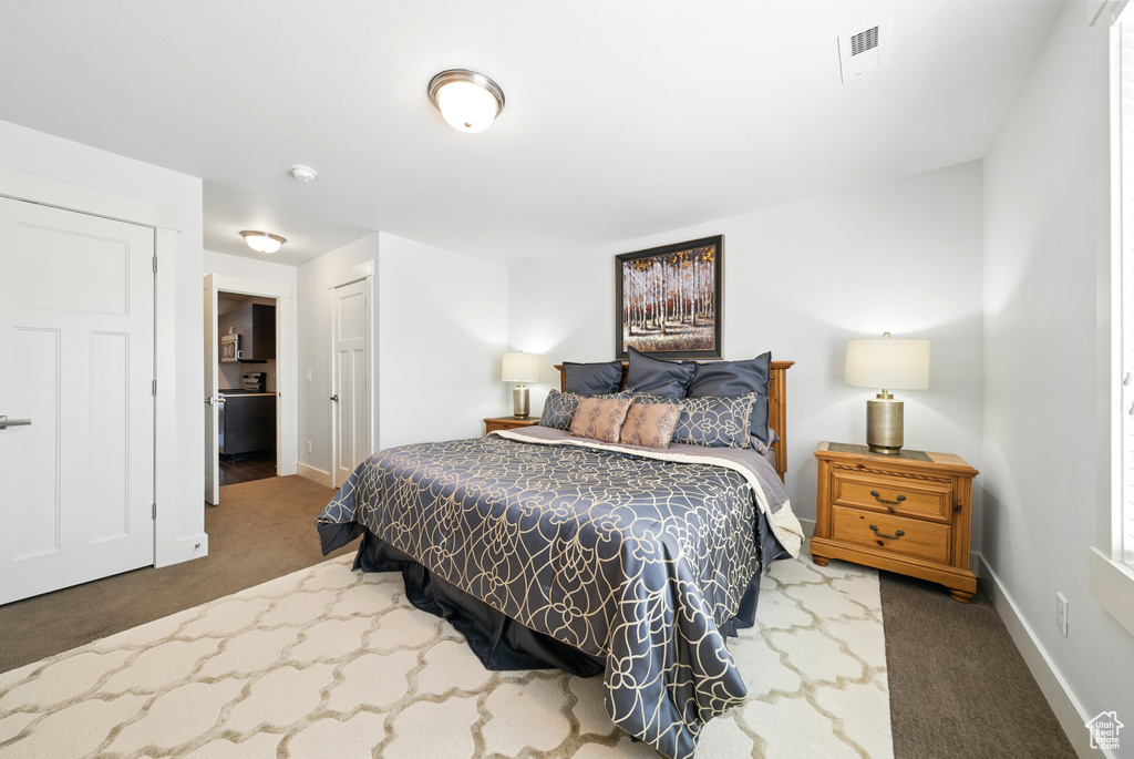 Carpeted bedroom featuring baseboards and a closet