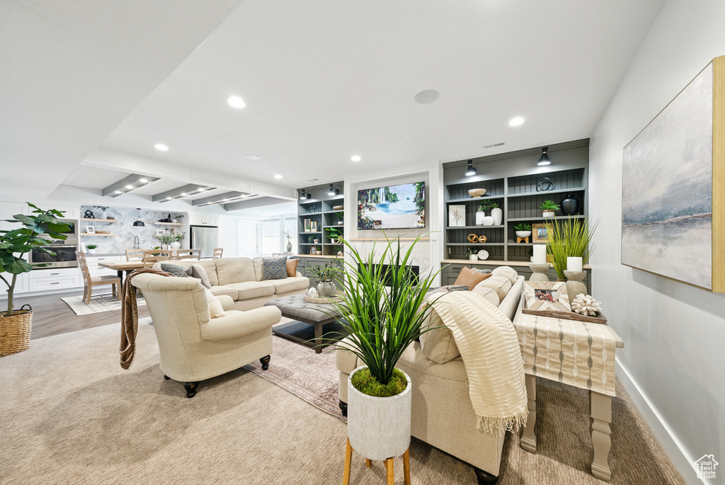 Carpeted living area featuring recessed lighting and baseboards