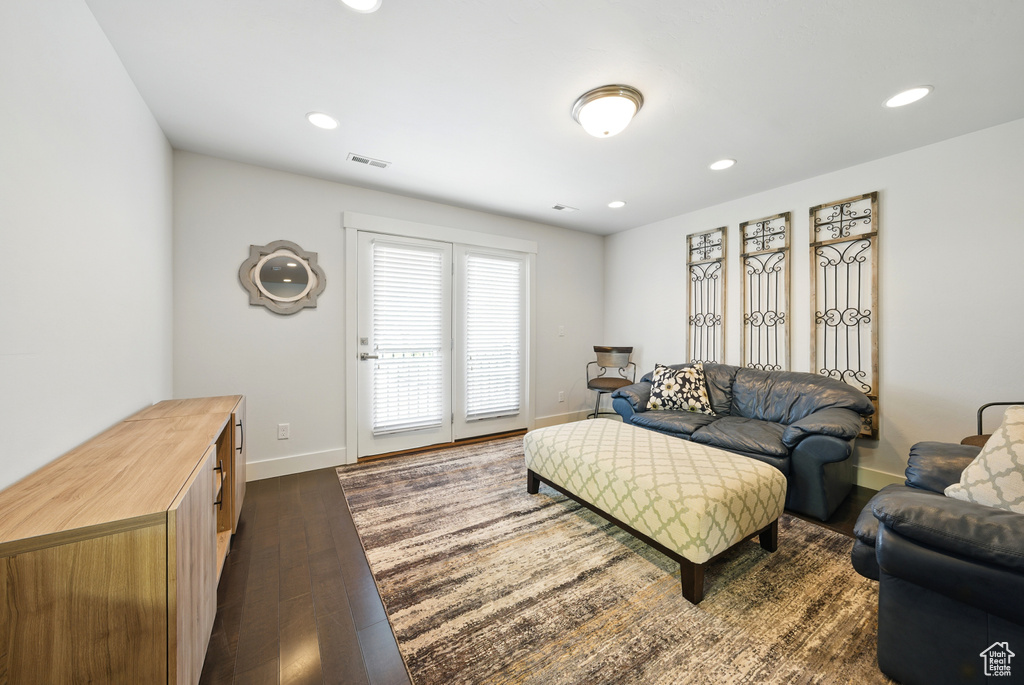 Living area featuring dark wood-type flooring and recessed lighting