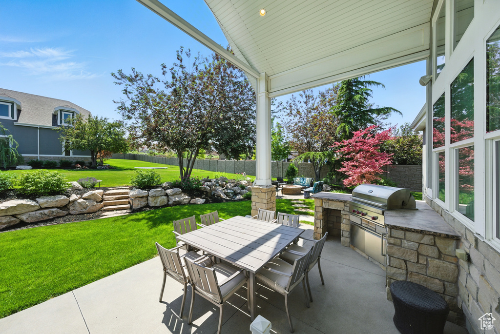 Fenced backyard featuring exterior kitchen, a patio area, and outdoor dining area