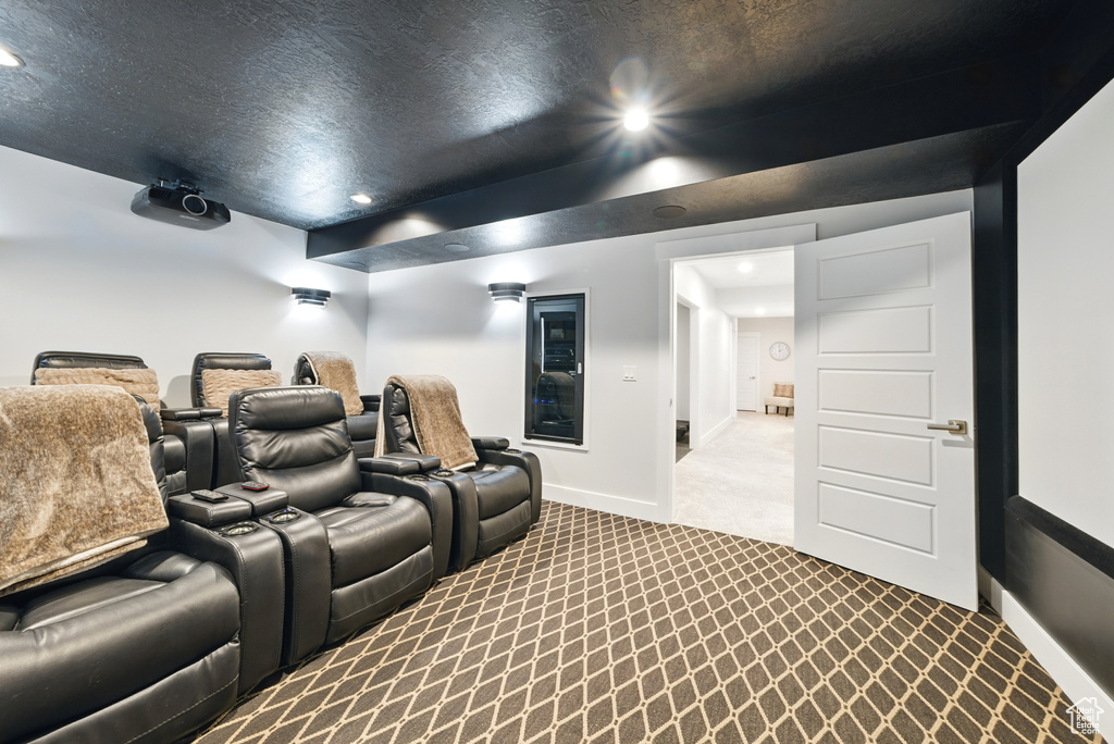 Cinema with dark colored carpet and recessed lighting