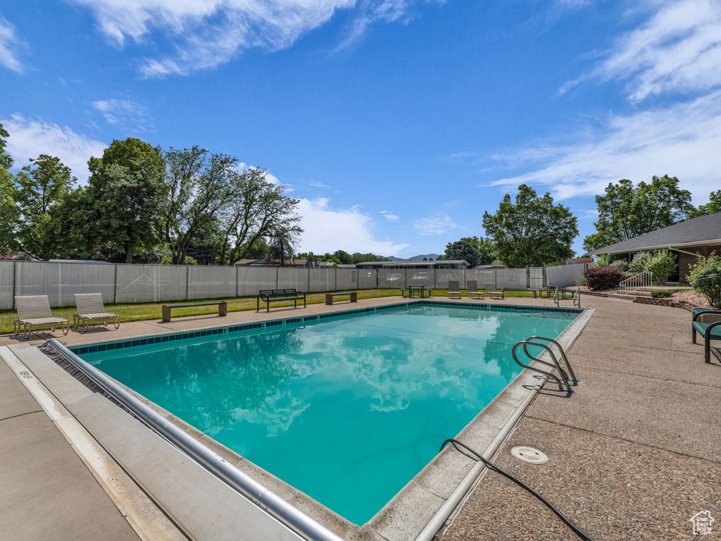 View of swimming pool featuring a fenced backyard and a patio