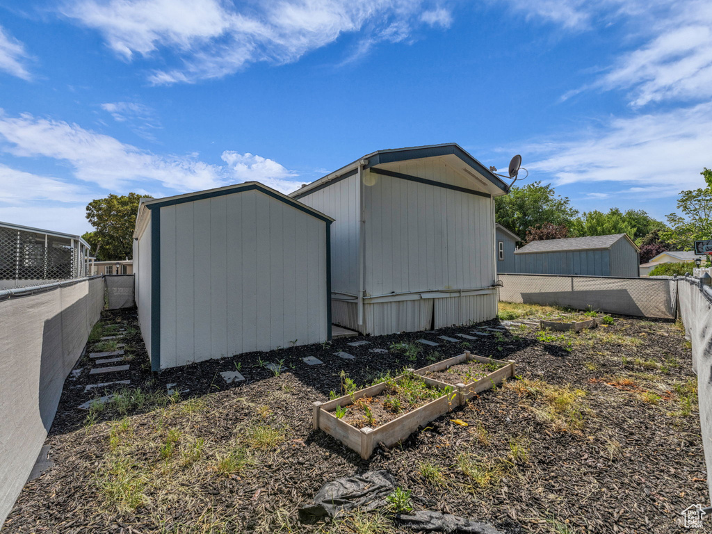View of shed with a garden and a fenced backyard