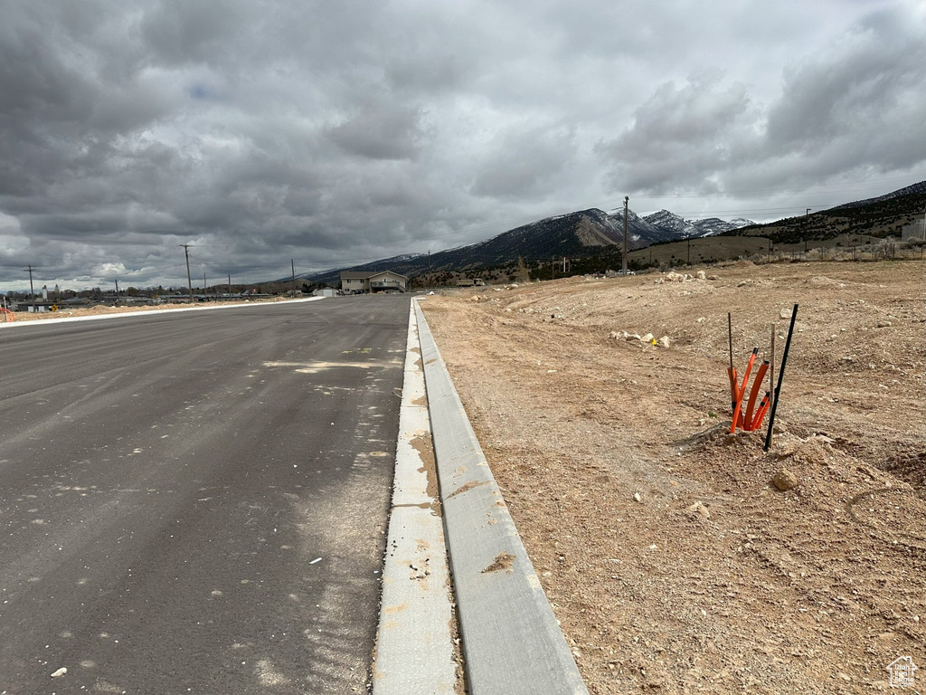View of asphalt street featuring curbs and a mountain view