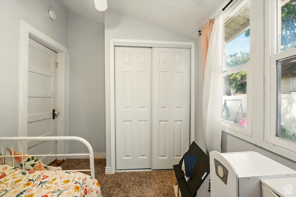 Carpeted bedroom with lofted ceiling and a closet