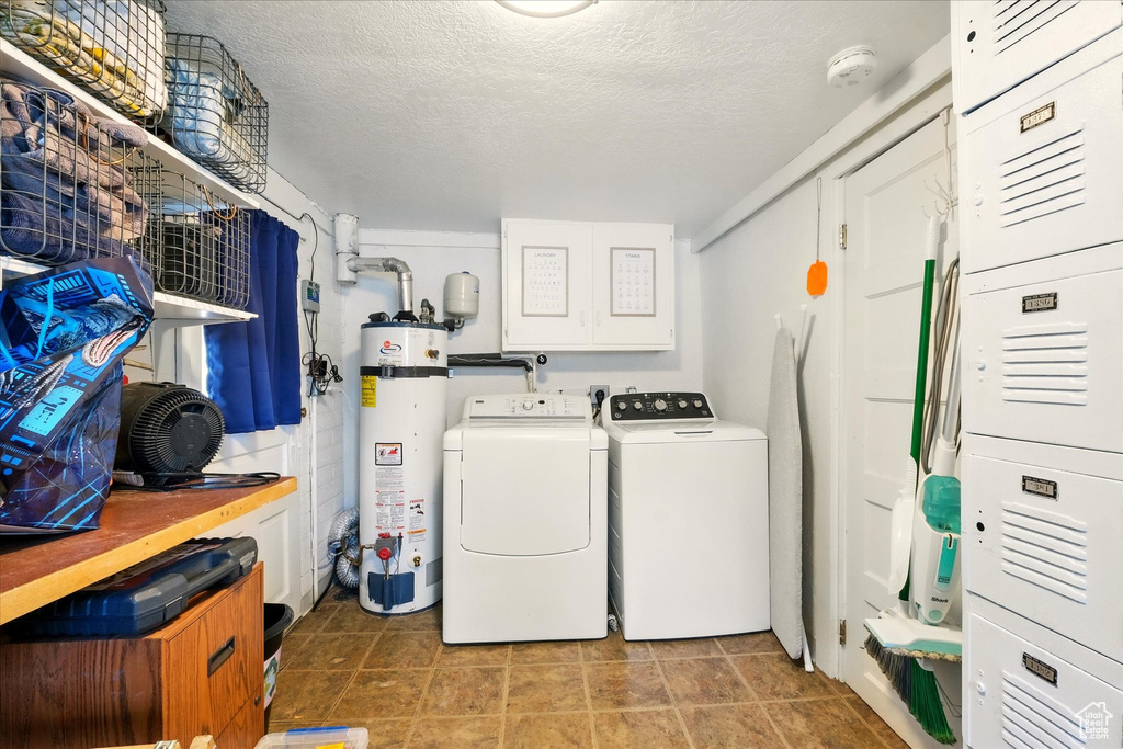 Laundry room with water heater, independent washer and dryer, and a textured ceiling