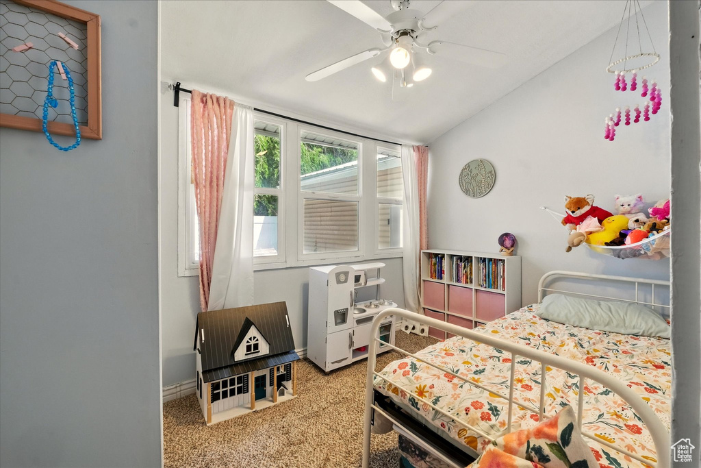 Carpeted bedroom with lofted ceiling and ceiling fan