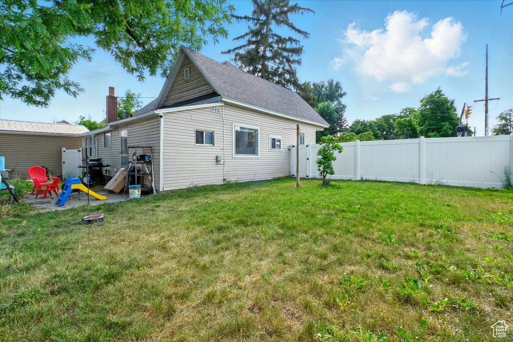 Rear view of house with a chimney and roof with shingles