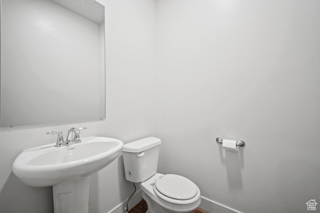 Half bathroom featuring baseboards and wood finished floors