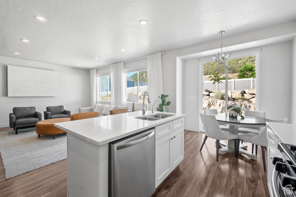 Kitchen with dishwasher, range, dark wood-style flooring, light countertops, and plenty of natural light