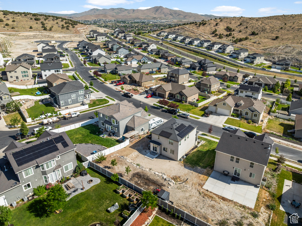 Aerial view of property and surrounding area featuring nearby suburban area and mountains