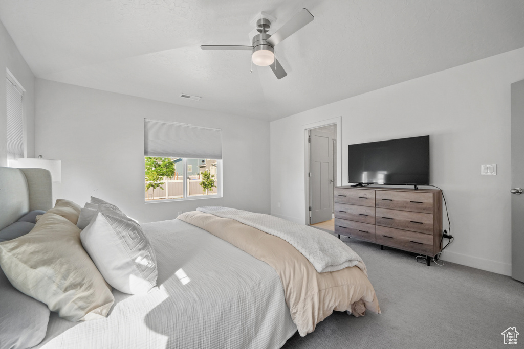 Carpeted bedroom with ceiling fan and baseboards