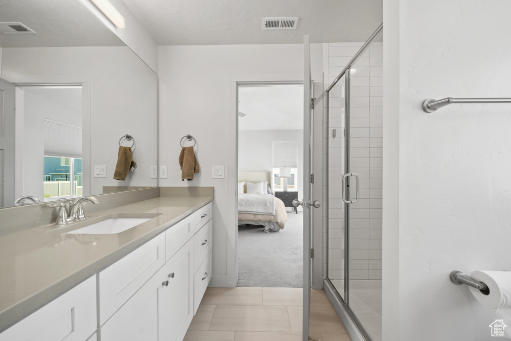 Bathroom with vanity, ensuite bath, a stall shower, and tile patterned floors