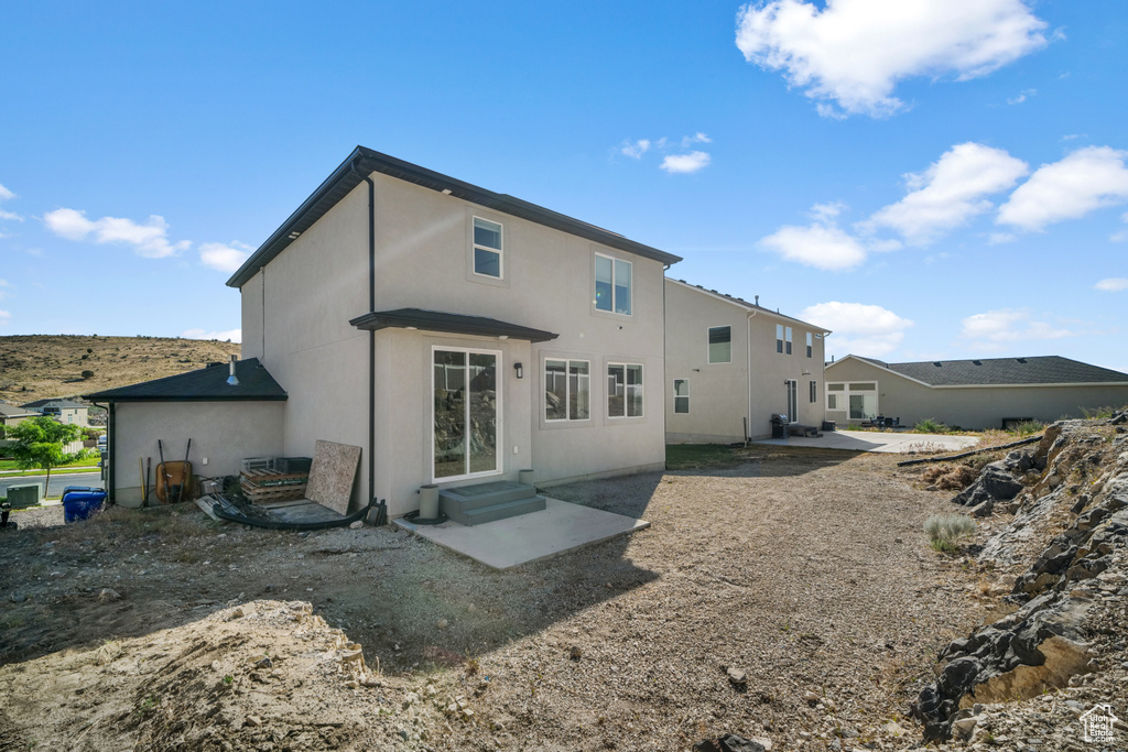 Rear view of house with a patio and stucco siding