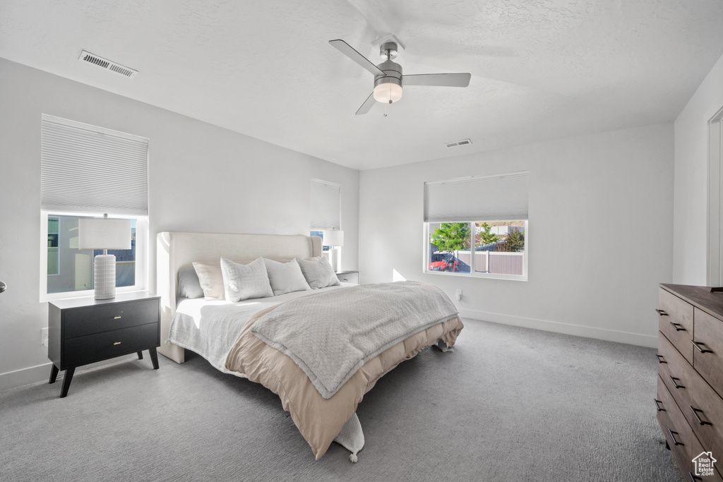 Bedroom with light carpet and a ceiling fan