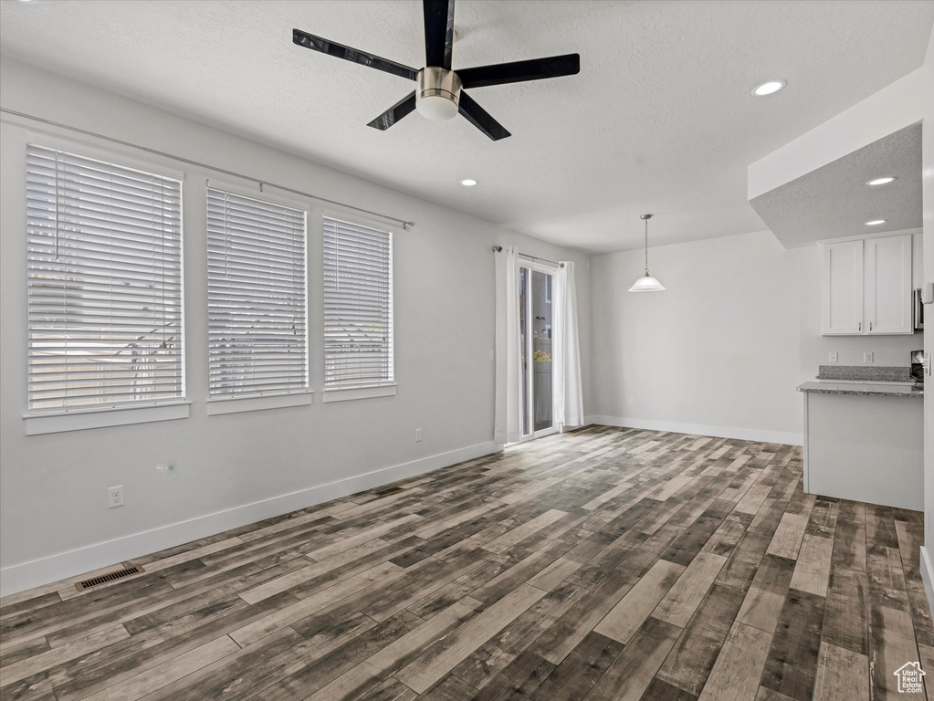 Unfurnished living room with a ceiling fan, dark wood-style flooring, recessed lighting, and plenty of natural light