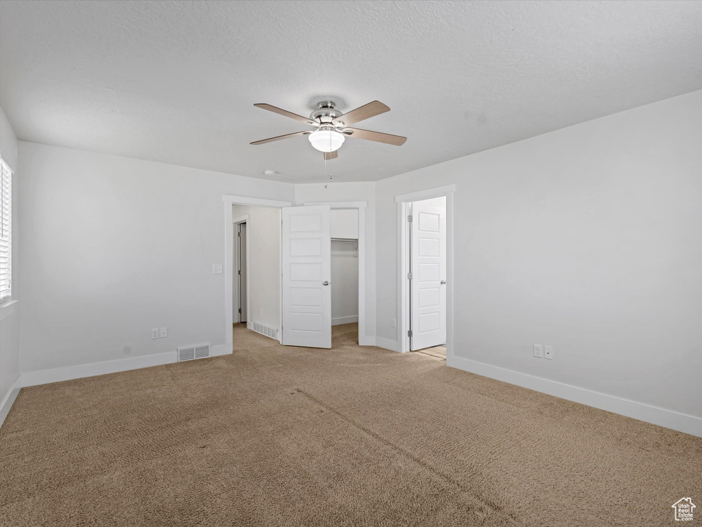 Unfurnished bedroom with light carpet, a ceiling fan, and a closet