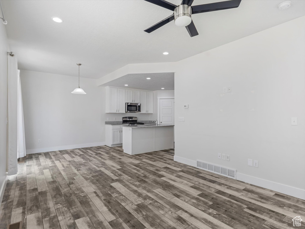 Unfurnished living room with wood finished floors, ceiling fan, and recessed lighting