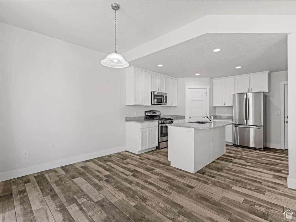 Kitchen featuring appliances with stainless steel finishes, dark wood-style floors, white cabinets, recessed lighting, and hanging light fixtures