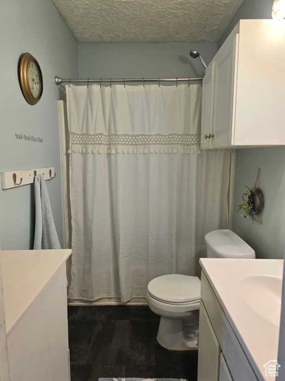 Bathroom with vanity, a textured ceiling, and curtained shower
