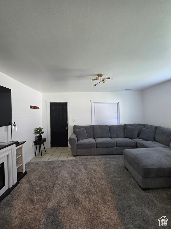 Carpeted living area with a chandelier, tile patterned floors, and a fireplace