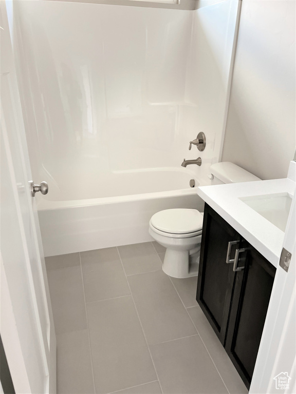 Bathroom with vanity, tile patterned floors, and shower / washtub combination