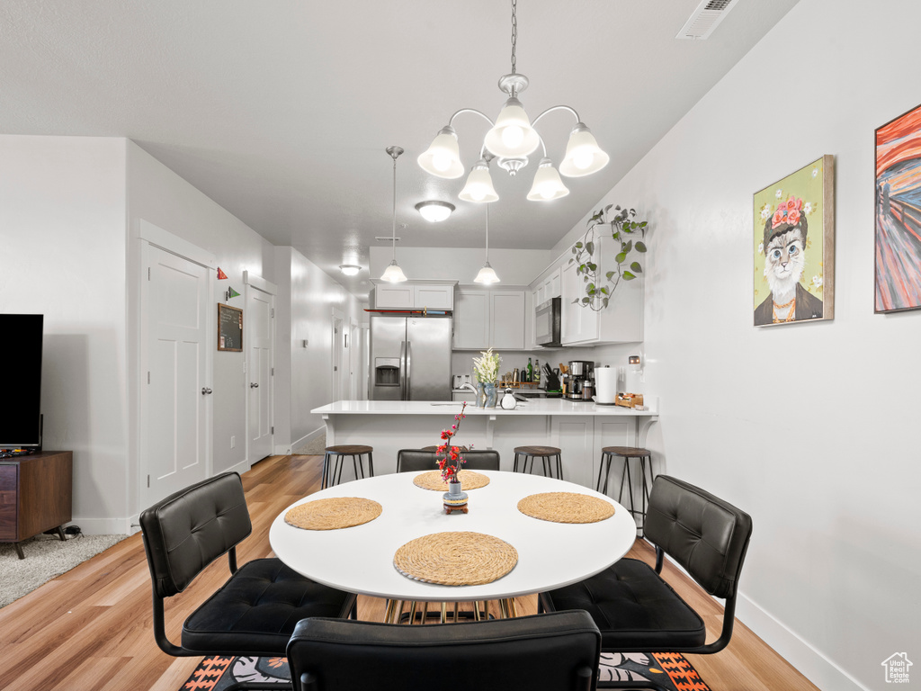 Dining room featuring a chandelier and light wood-style flooring