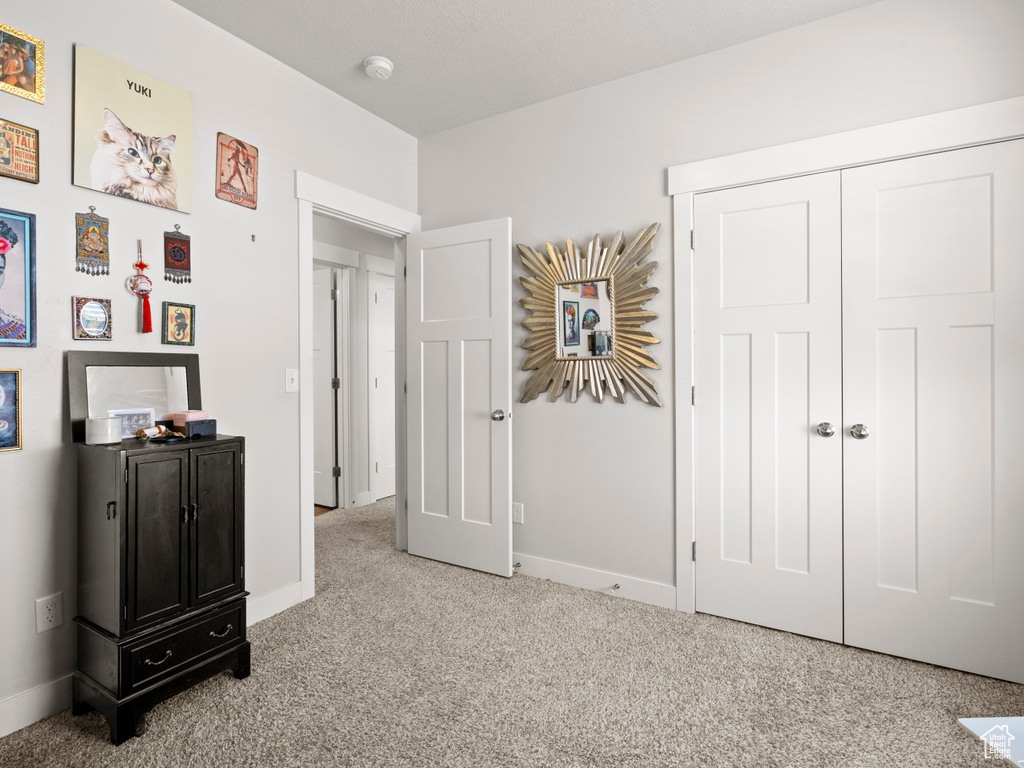 Carpeted bedroom featuring baseboards and a closet