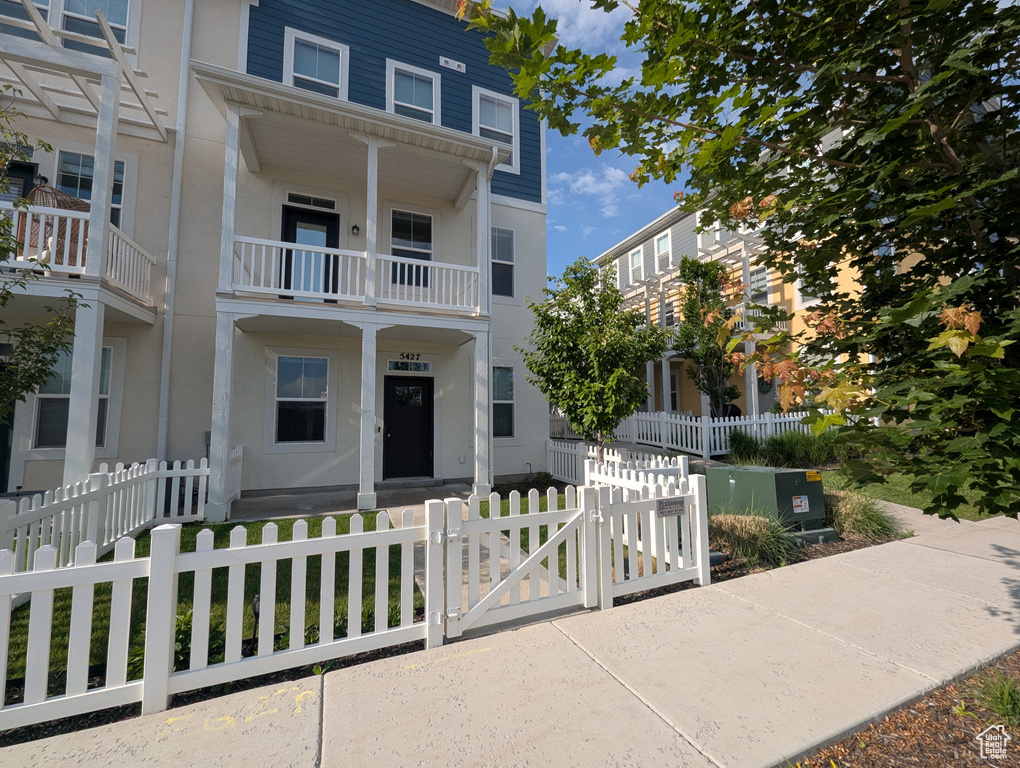 View of front of home featuring a gate, stucco siding, and a fenced front yard
