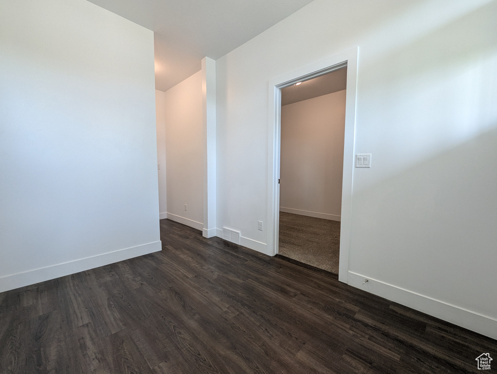 Spare room with dark wood finished floors and baseboards