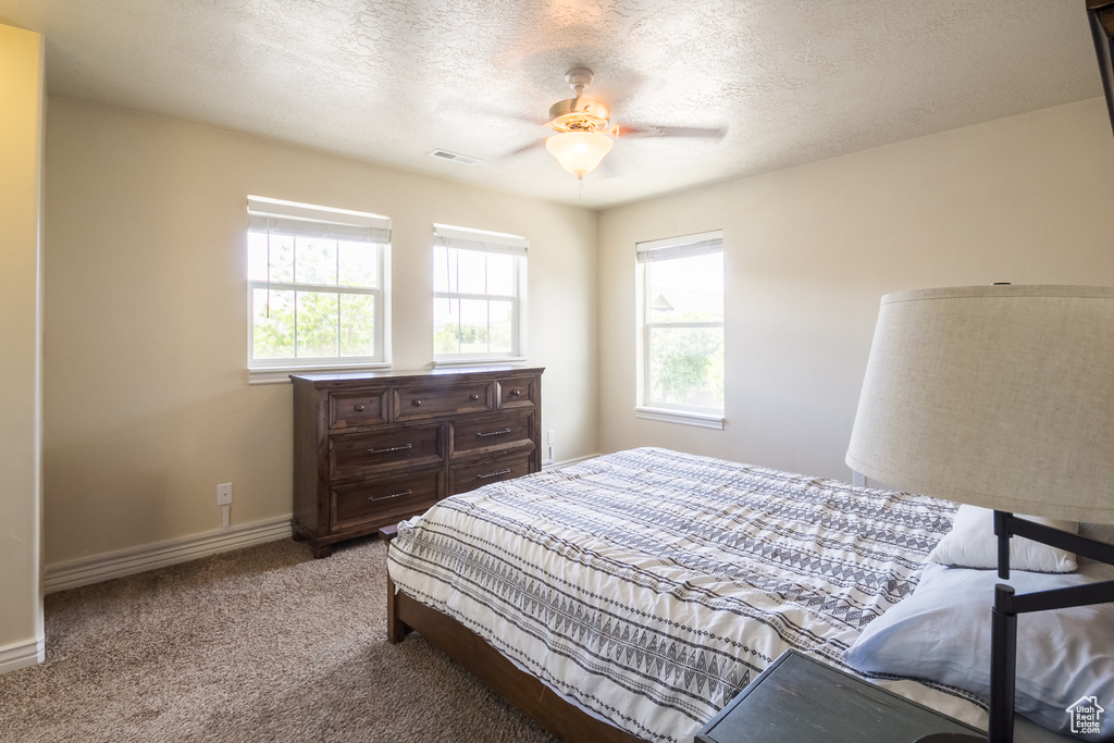 Bedroom featuring carpet floors, a textured ceiling, and a ceiling fan