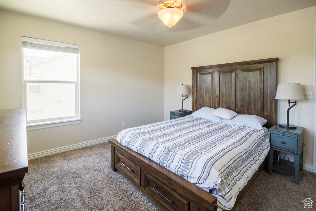 Carpeted bedroom featuring baseboards and ceiling fan