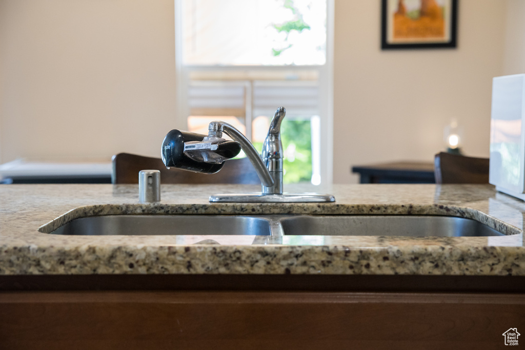 Kitchen view of a sink and light stone countertops