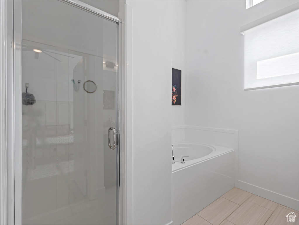 Full bath featuring a stall shower, a bath, and plenty of natural light