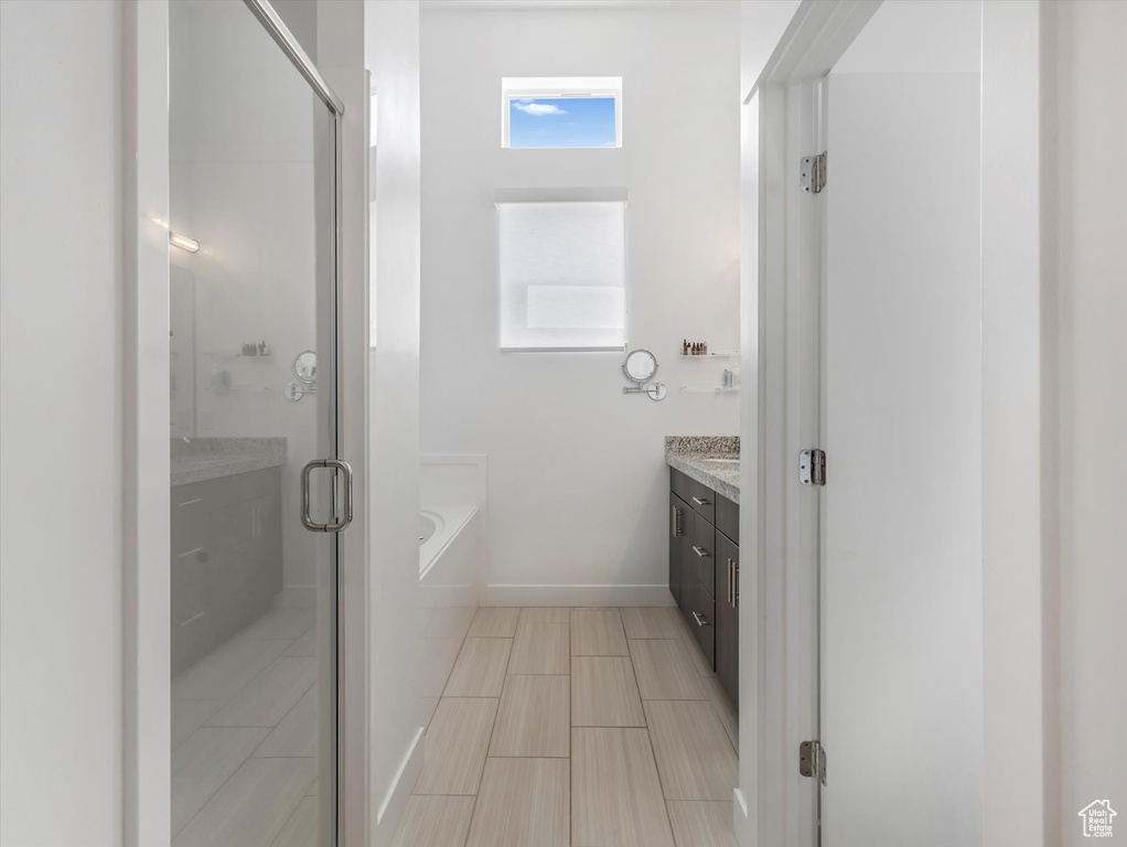 Full bath featuring vanity, a garden tub, and a stall shower