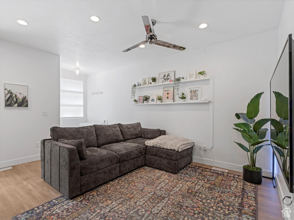 Living room featuring ceiling fan, wood finished floors, and recessed lighting