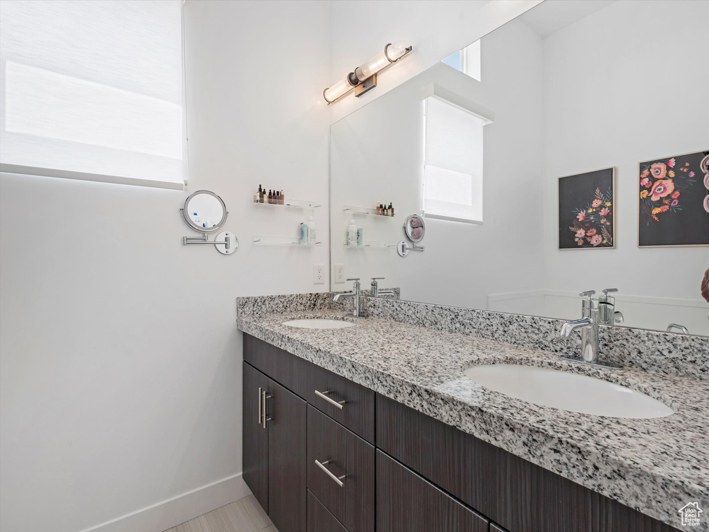 Bathroom featuring double vanity and baseboards