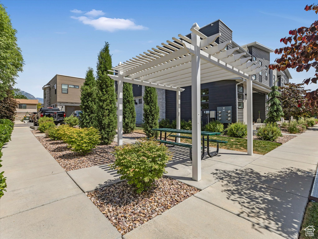 Surrounding community featuring mail area and a pergola