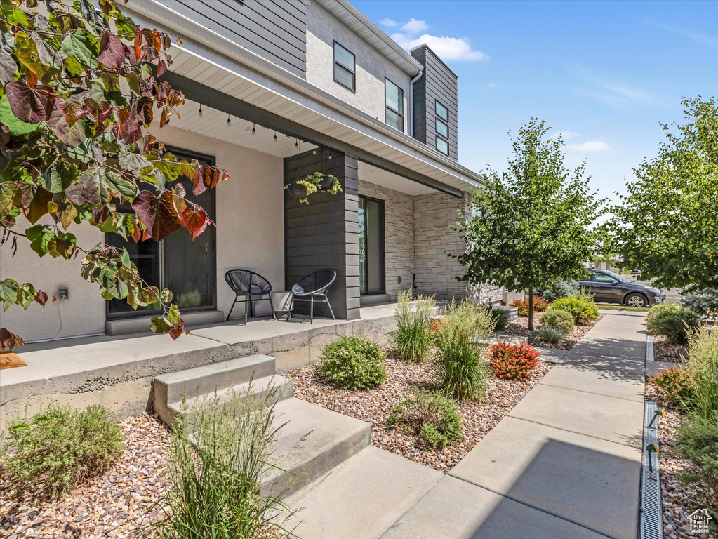 View of exterior entry featuring a porch and stucco siding
