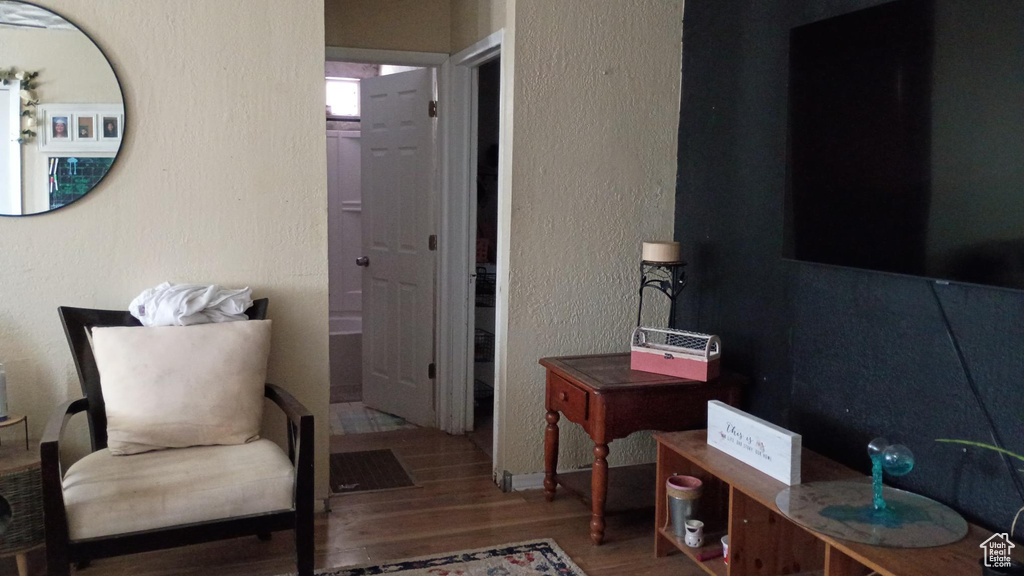 Sitting room featuring wood finished floors and a textured wall